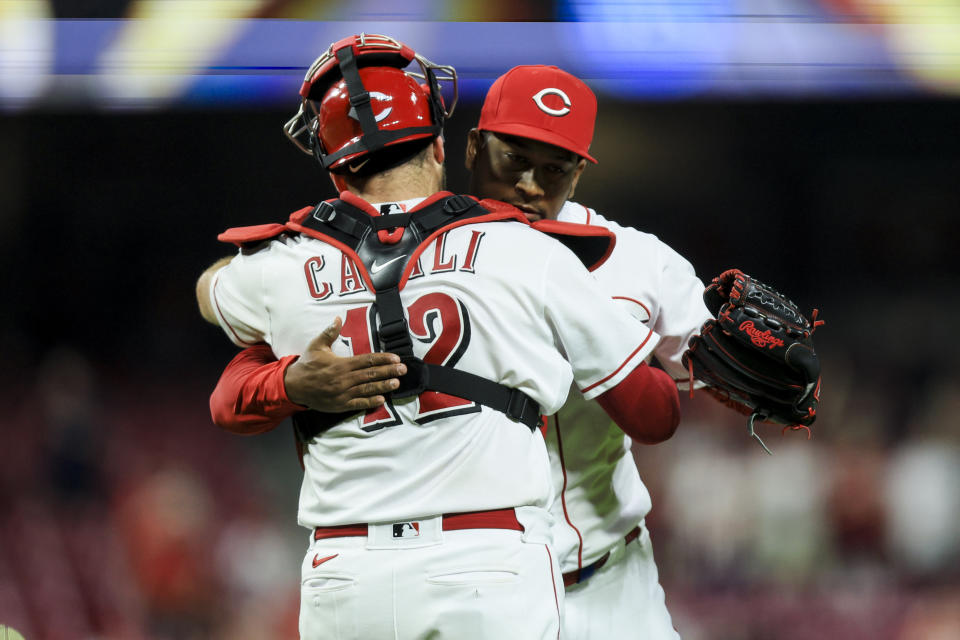 Cincinnati Reds' Curt Casali, left, hugs Alexis Diaz after the final out of a baseball game against the Philadelphia Phillies in Cincinnati, Thursday, April 13, 2023. (AP Photo/Aaron Doster)