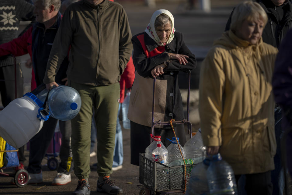 Olha Fedorivna, 83, waits to refill her plastic bottles with drinking water from a tank in the center of Mykolaiv, Monday, Oct. 24, 2022. Since mid-April, citizens of Mykolaiv, with a pre-war population of half a million people, have lived without a centralized drinking water supply. Russian Forces cut off the pipeline through which the city received drinking water for the last 40 years. (AP Photo/Emilio Morenatti)