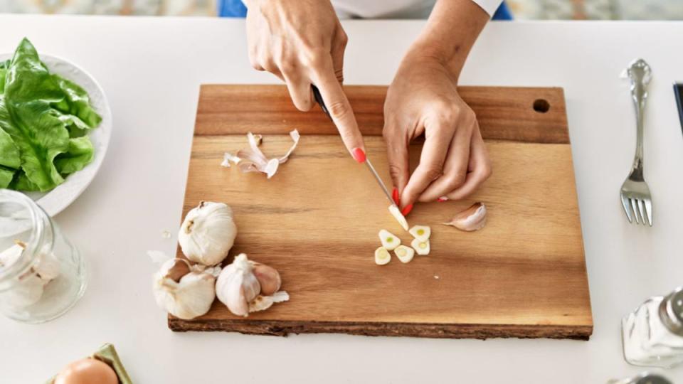 Hands cutting garlic