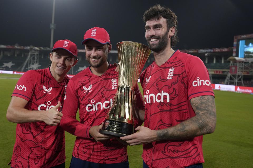 England's, from left to right, Sam Curran, Will Jacks and Reece Topley pose for photograph with the trophy, after winning the twenty20 series, on the end of the seventh twenty20 cricket match between Pakistan and England, in Lahore, Pakistan, Sunday, Oct. 2, 2022. (AP Photo/K.M. Chaudary)