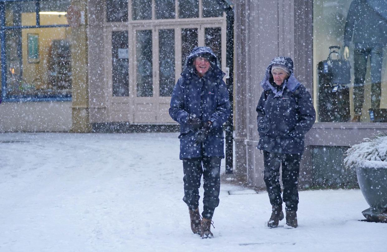 People walking in the snow in Keswick in Cumbria. Much of Britain is facing another day of cold temperatures and travel disruption after overnight lows dropped below freezing for the bulk of the country. A 