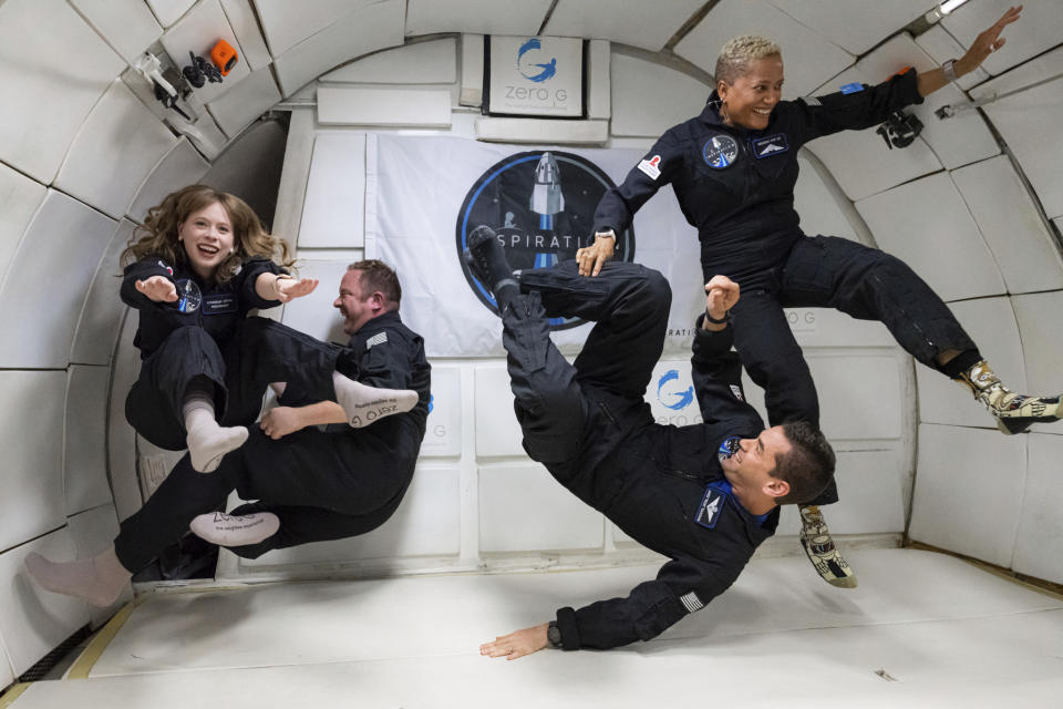 In this July 11, 2021 photo provided by John Kraus, from left, Hayley Arceneaux, Chris Sembroski, Jared Isaacman and Sian Proctor float during a zero gravity flight out of Las Vegas. The plane, a modified Boeing 727, flies multiple parabolic arcs to provide 20-30 seconds of weightlessness. (John Kraus/Inspiration4 via AP)