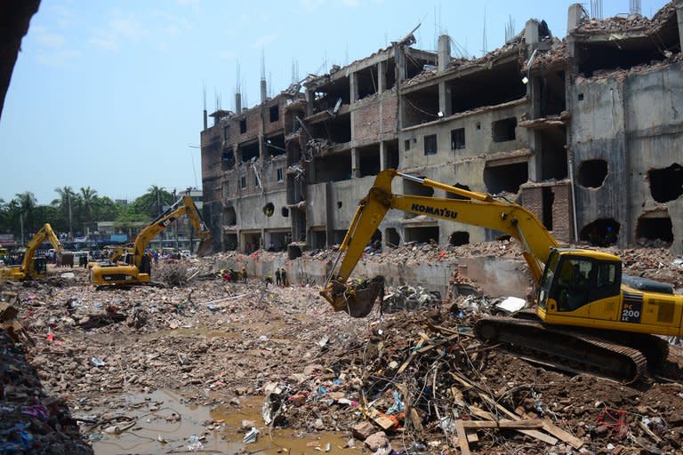 Bangladeshi soldiers use heavy equipment to clear debris after an eight-storey building collapsed in Savar, on the outskirts of Dhaka, on May 13, 2013. Bangladesh garment manufacturers said Thursday they would reopen hundreds of factories in a hub outside Dhaka, days after they were shuttered due to unrest over the country's worst industrial tragedy