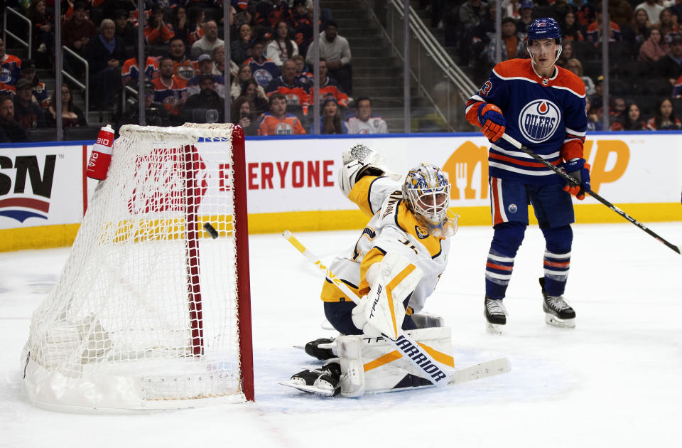 Nashville Predators goalie Kevin Lankinen (32) makes the save as Edmonton Oilers' Ryan Nugent-Hopkins (93) looks for the rebound during the second period of an NHL hockey game in Edmonton on Saturday Nov. 4, 2023. (Jason Franson/The Canadian Press via AP)