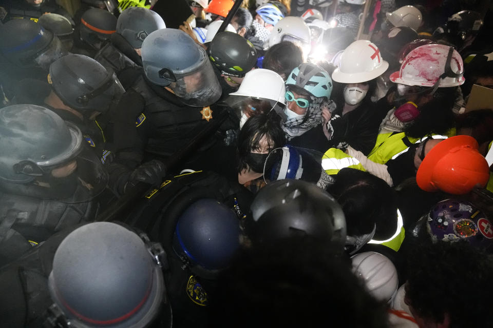 Police face off with pro-Palestinian demonstrators inside an encampment on the UCLA campus Thursday, May 2, 2024, in Los Angeles. (AP Photo/Jae C. Hong)