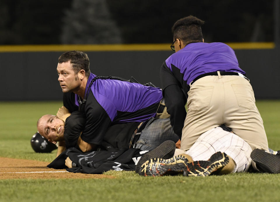 Colorado Rockies security staff tackle fans who ran out on to the field during the 7th inning against the Los Angeles Dodgers August 2, 2016 at Coors Field. (Photo By John Leyba/The Denver Post via Getty Images)