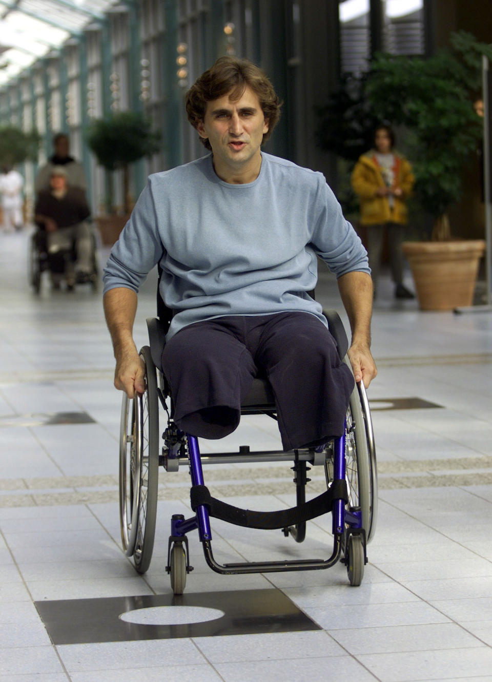 FILE - In this Oct. 30, 2001, file photo, Italian driver Alex Zanardi proceeds down the aisle of Berlin's Trauma Center, following a press conference on his recuperation. Zanardi lost both legs in an accident at the inaugural American Memorial 500 auto race in Lausitz, Germany. Now 52, Zanardi has seized every moment in the 17 years since and will cross off yet another remarkable achievement this weekend at Daytona International Raceway when he competes in the prestigious Rolex 24 at Daytona endurance race. (AP Photo/Jockel Finck, File)