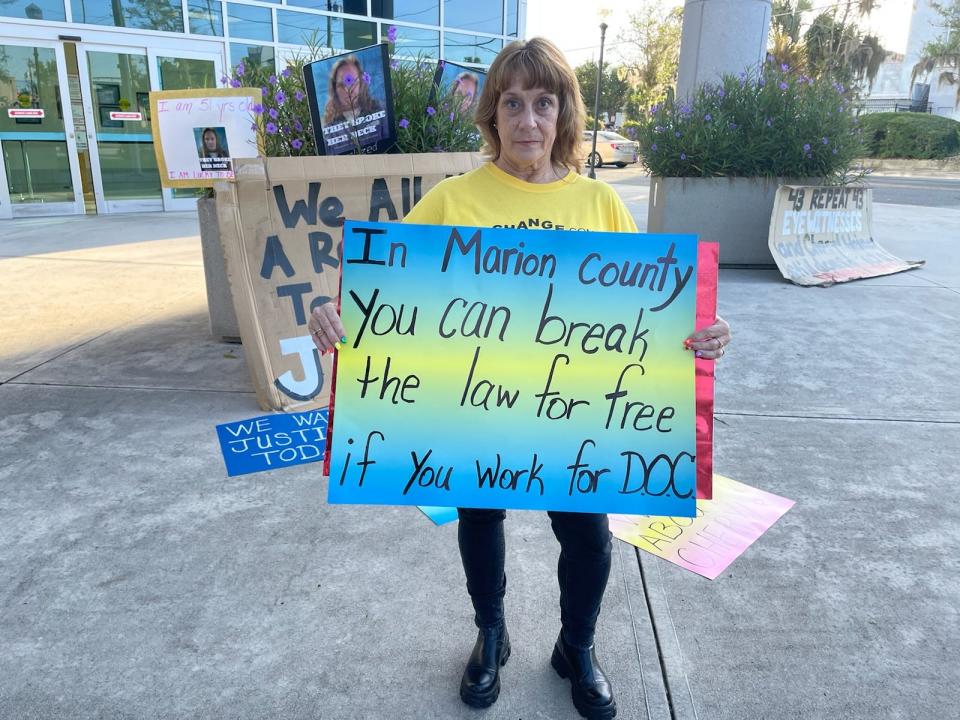 Debra Bennett holding a sign in front of the Marion County Judicial Center on Wednesday morning for Keith Mitchell Turner's trial.