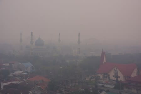 A mosque and a church are pictured as smog covers the city due to the forest fire in Pekanbaru