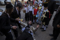 Ultra-Orthodox Jews celebrate after drinking alcohol during the Jewish holiday of Purim, in the Mea Shearim ultra-Orthodox neighborhood in Jerusalem, Sunday, Feb. 28, 2021. The Jewish holiday of Purim commemorates the Jews' salvation from genocide in ancient Persia, as recounted in the biblical Book of Esther. (AP Photo/Oded Balilty)