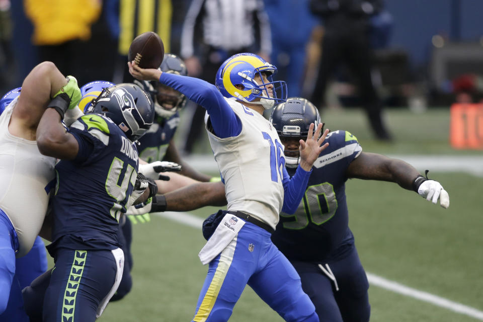 Los Angeles Rams quarterback Jared Goff passes as Seattle Seahawks defensive tackle Jarran Reed, right, pressures him during the first half of an NFL wild-card playoff football game, Saturday, Jan. 9, 2021, in Seattle. (AP Photo/Scott Eklund)
