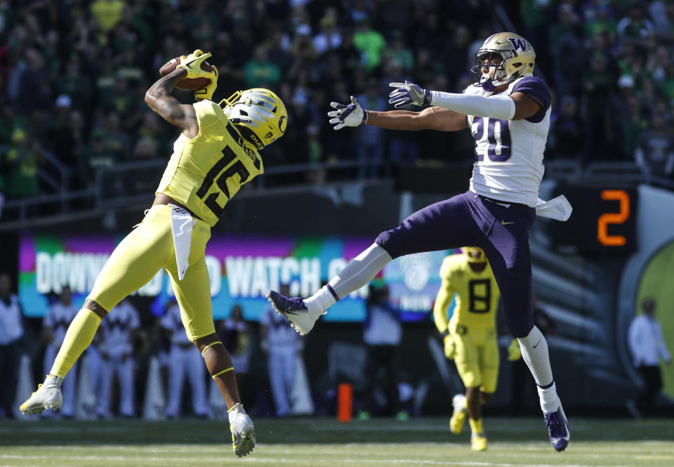 Oregon cornerback Deommodore Lenoir (15), intercepts a pass intended for Washington wide receiver Ty Jones (20), on Washington's first drive during a NCAA college football game in Eugene, Ore., Saturday, Oct. 13, 2018. The play set up an Oregon field goal. (AP Photo/Thomas Boyd)