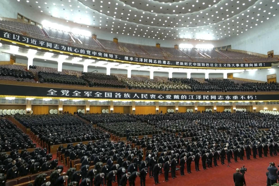 In this image taken from video footage run by China's CCTV, attendees bow during a formal memorial for the late former Chinese President Jiang Zemin at the Great Hall of the People in Beijing on Tuesday, Dec. 6, 2022. (CCTV via AP)