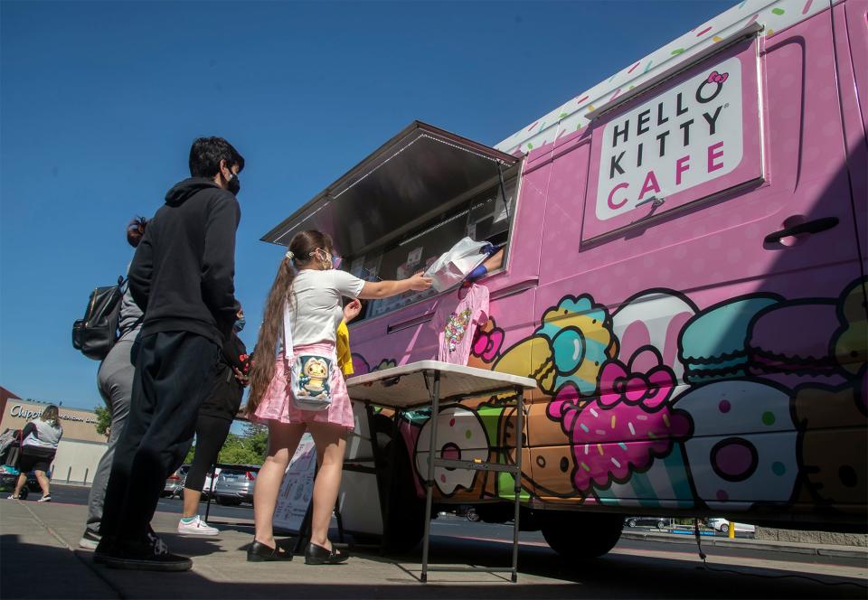 People purchase merchandise from the Hello Kitty Cafe van in front of the Weberstown Mall in Stockton.