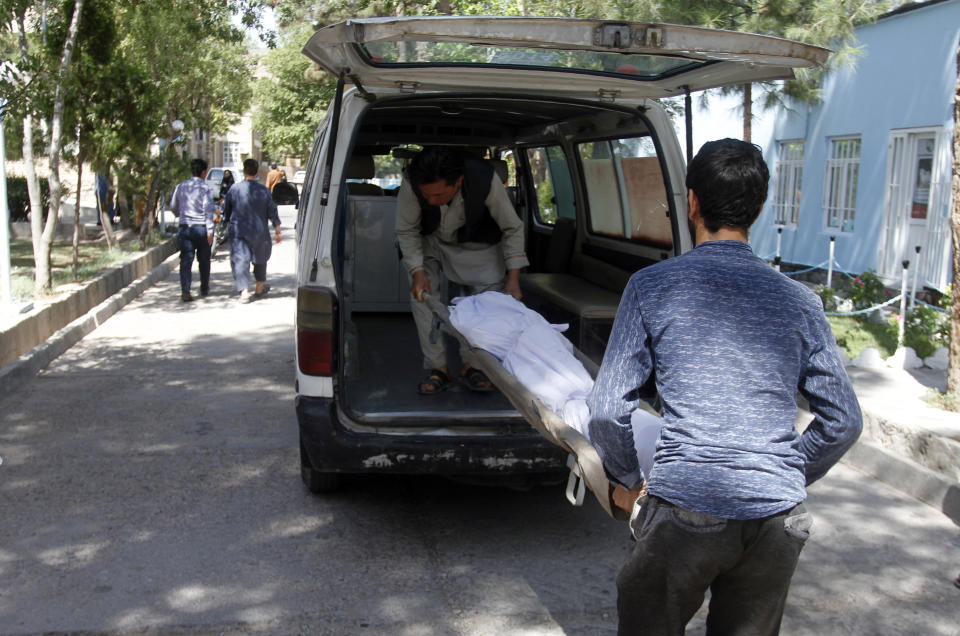 Afghans carry the dead body of a victim in a hospital after a roadside bomb on the main highway between the western city of Herat and the southern city of Kandahar, in Herat, Afghanistan, Wednesday, July 31, 2019. A roadside bomb tore through a bus in western Afghanistan on Wednesday, killing at least 32 people, including children, a provincial official said. (AP Photo/Hamed Sarfarazi)