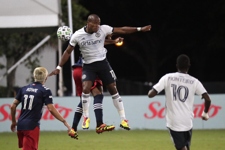 Philadelphia Union forward Sergio Santos (17) goes up for a header against New England Revolution defender Andrew Farrell during the first half of an MLS soccer match, Saturday, July 25, 2020, in Kissimmee, Fla. (AP Photo/John Raoux)