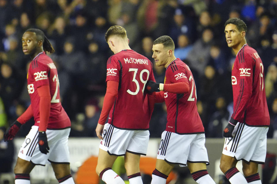 Manchester United's Diogo Dalot, second right, celebrates with teammates after scoring his side's first goal during the English FA Cup third round soccer match between Wigan Athletic and Manchester United at the DW Stadium, Wigan, England, Monday, Jan. 8, 2024. (AP Photo/Jon Super)