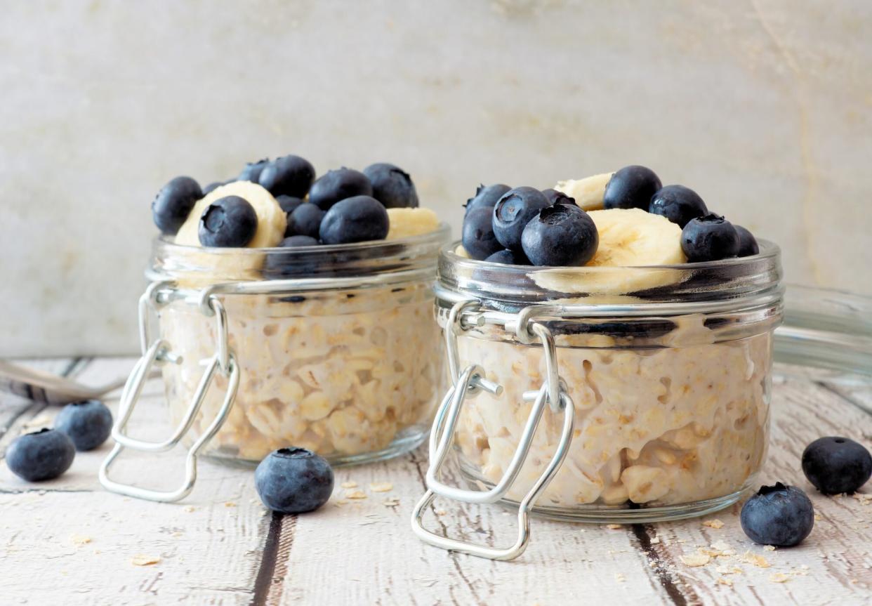 Overnight oats with blueberries and bananas on a white wood background