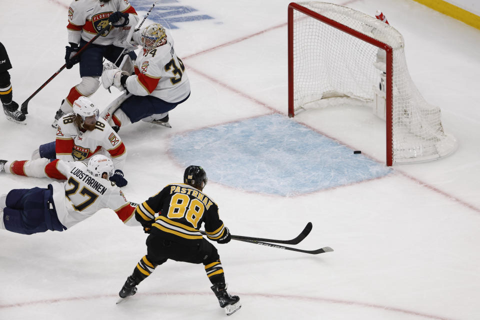 As Florida Panthers goaltender Alex Lyon (34) looks back, Boston Bruins' David Pastrnak (88) shoots the puck into an empty net for a goal during the first period of Game 1 of an NHL hockey playoff series Monday, April 17, 2023, in Boston. (AP Photo/Winslow Townson)