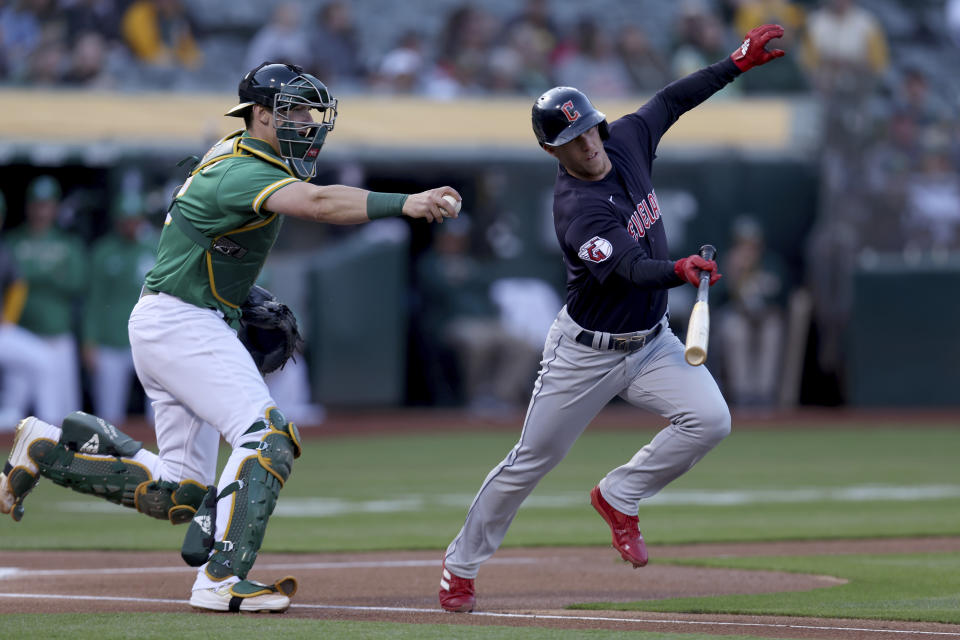 Cleveland Guardians' Myles Straw, right, runs to first base on a dropped third strike as Oakland Athletics catcher Sean Murphy, left, attempts the tag during the first inning of a baseball game in Oakland, Calif., Friday, April 29, 2022. (AP Photo/Jed Jacobsohn)