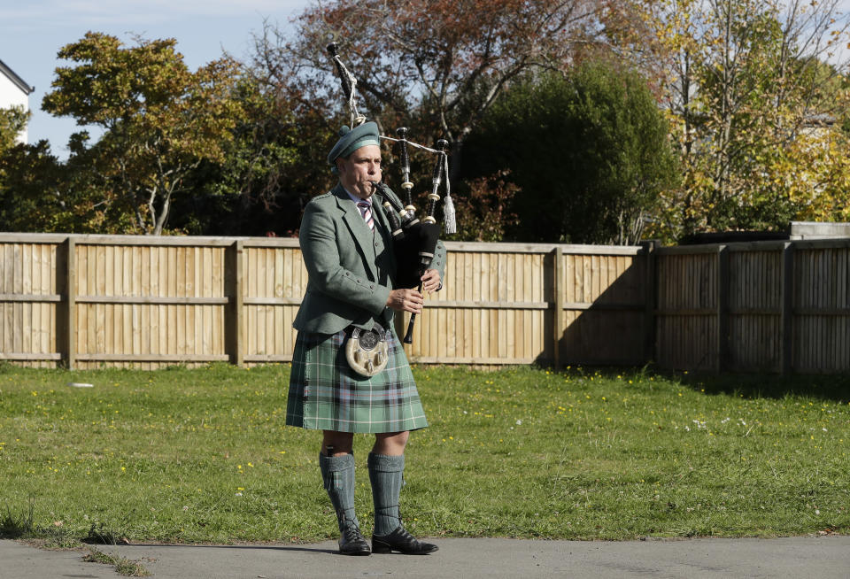 Tom Glover plays the bagpipes to his neighbors to commemorate Anzac Day in a suburb of Christchurch, New Zealand, Saturday, April 25, 2020. Many New Zealanders participated in the "Stand At Dawn" initiative earlier in the day to commemorate Anzac Day due to the traditional services being canceled because of COVID-19. (AP Photo/Mark Baker)