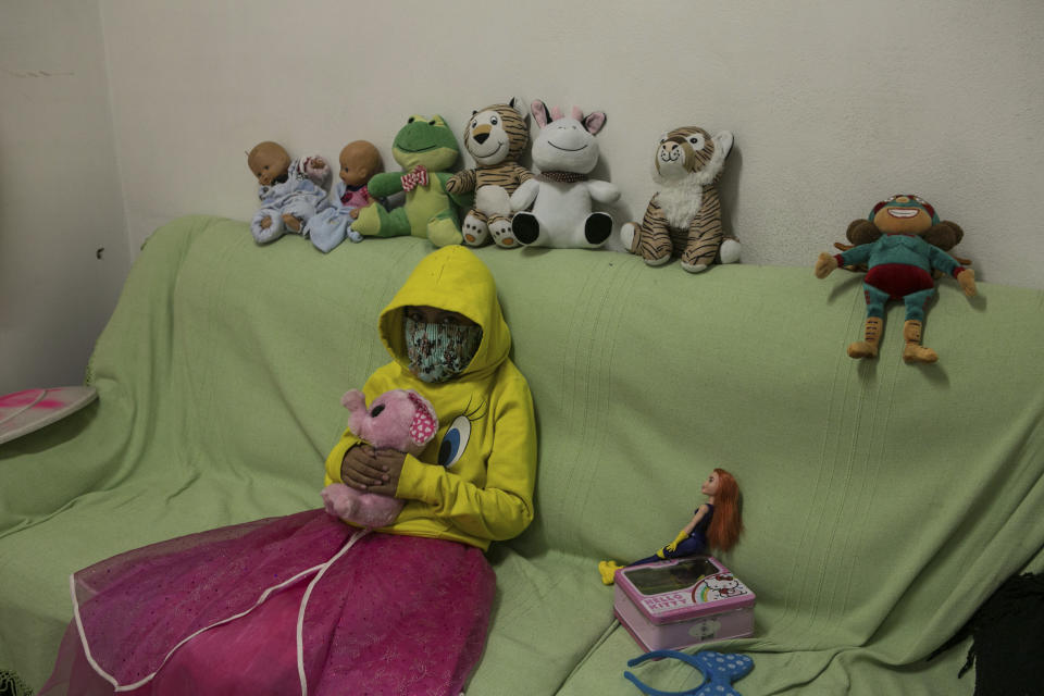 A 10-year-old victim of sexual abuse, who keeps her face covered to hide her identity, poses for a portrait with her stuffed animals inside the Mexican Human Rights Commission (CNDH) headquarters where she has been living with her grandmother, mother, cousin, and two brothers after women’s rights activists occupied the building and turned it into a refuge for victims of gender violence almost three months ago in Mexico City, Tuesday, Nov. 17, 2020. The 10-year-old suffered sexual abuse at age 7, which her mother reported to authorities, but it’s the more recent abuse of her 11-year-old cousin that led them to leave home and take refuge here. (AP Photo/Ginnette Riquelme)