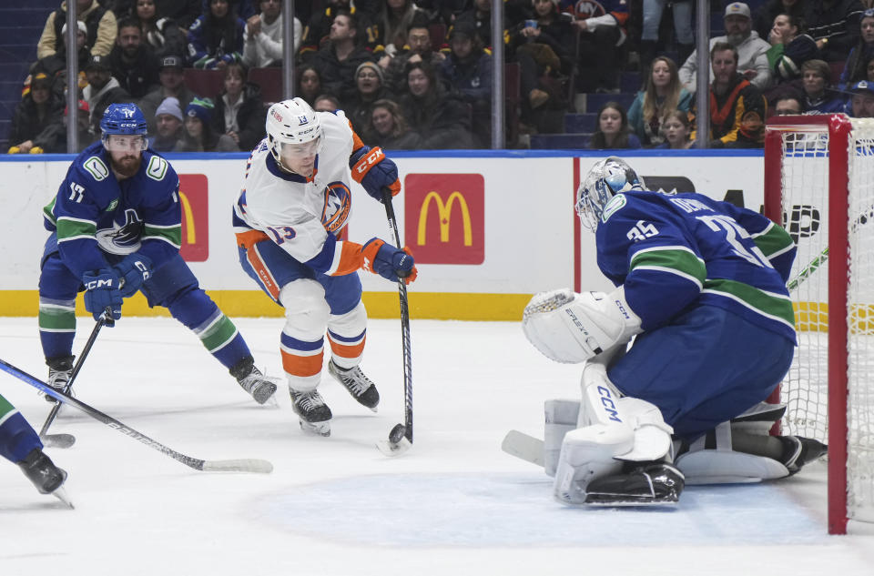 Vancouver Canucks goalie Thatcher Demko, right, stops New York Islanders' Mathew Barzal (13) as Canucks' Filip Hronek watches during the third period of an NHL hockey game Wednesday, Nov. 15, 2023, in Vancouver, British Columbia. (Darryl Dyck/The Canadian Press via AP)