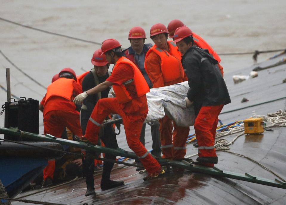 Rescue workers carry a body from the sunken ship in the Jianli section of Yangtze River, Hubei province, China, June 2, 2015. Rescuers fought bad weather on Tuesday as they searched for more than 400 people, many of them elderly Chinese tourists, missing after a ship capsized on the Yangtze River in what was likely China's worst shipping disaster in almost 70 years. (REUTERS/Kim Kyung-Hoon)