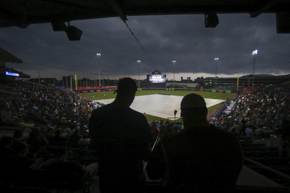 Fans stand as the baseball game between the Toronto Blue Jays and Boston Red Sox is postponed due to inclement weather Tuesday, July 20, 2021, in Buffalo, N.Y. (AP Photo/Joshua Bessex)