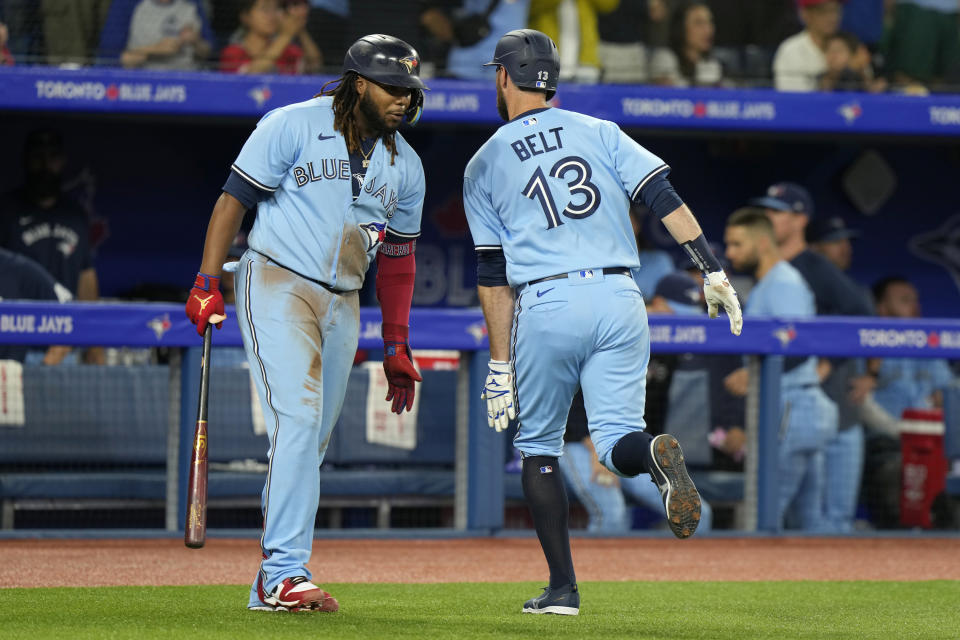 Toronto Blue Jays' Vladimir Guerrero Jr., left, congratulates teammate Brandon Belt (13) who hit a solo home run against the Boston Red Sox during first-inning baseball game action in Toronto, Sunday, July 2, 2023. (Frank Gunn/The Canadian Press via AP)