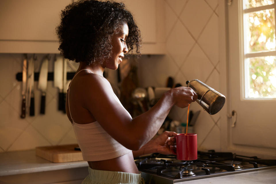 person pouring coffee into their mug at home