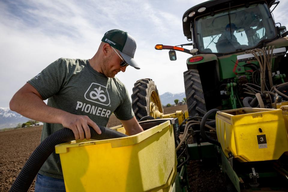 Landon Potter, an account manager for Pioneer Hi-Bred, vacuums excess corn seed from a planter while Ron Gibson, owner of Gibson’s Green Acres and president of the Utah Farm Bureau, plants a field with test crops at his farm in Ogden on Thursday, May 4, 2023. | Spenser Heaps, Deseret News