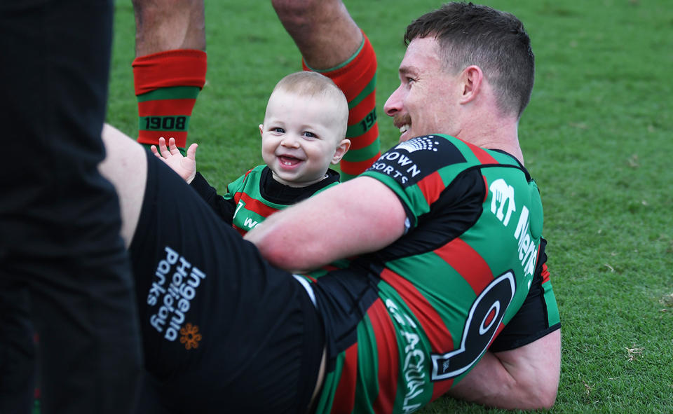 Damien Cook, pictured here with his son after a game for the Rabbitohs in 2023.