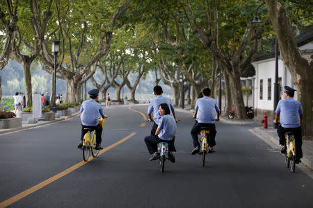 Security personnel ride bicycles on an empty road near the West Lake, as police closed off many roads before G20 Summit in Hangzhou, Zhejiang Province, China August 31, 2016. REUTERS/Aly Song