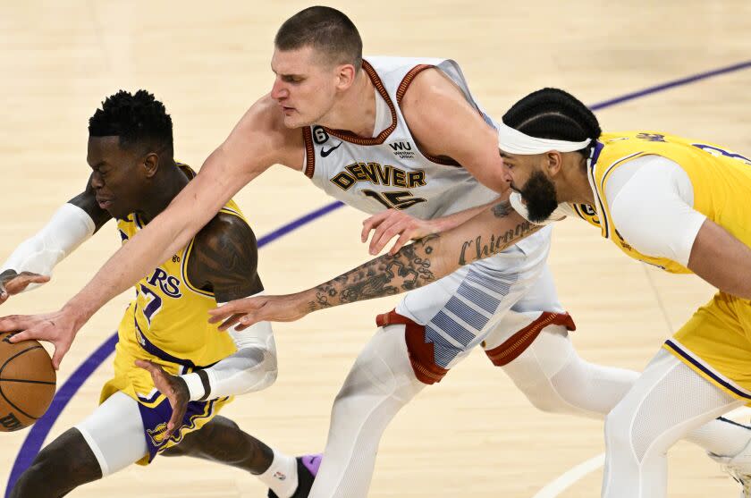 LOS ANGELES, CA - MAY 22: Los Angeles Lakers guard Dennis Schroder, left, battles for the loose ball with Denver Nuggets center Nikola Jokic, center, in front of forward Anthony Davis during the third quarter of game four in the NBA Playoffs Western Conference Finals at Crypto.com Arena on Monday, May 22, 2023 in Los Angeles, CA. (Gina Ferazzi / Los Angeles Times)