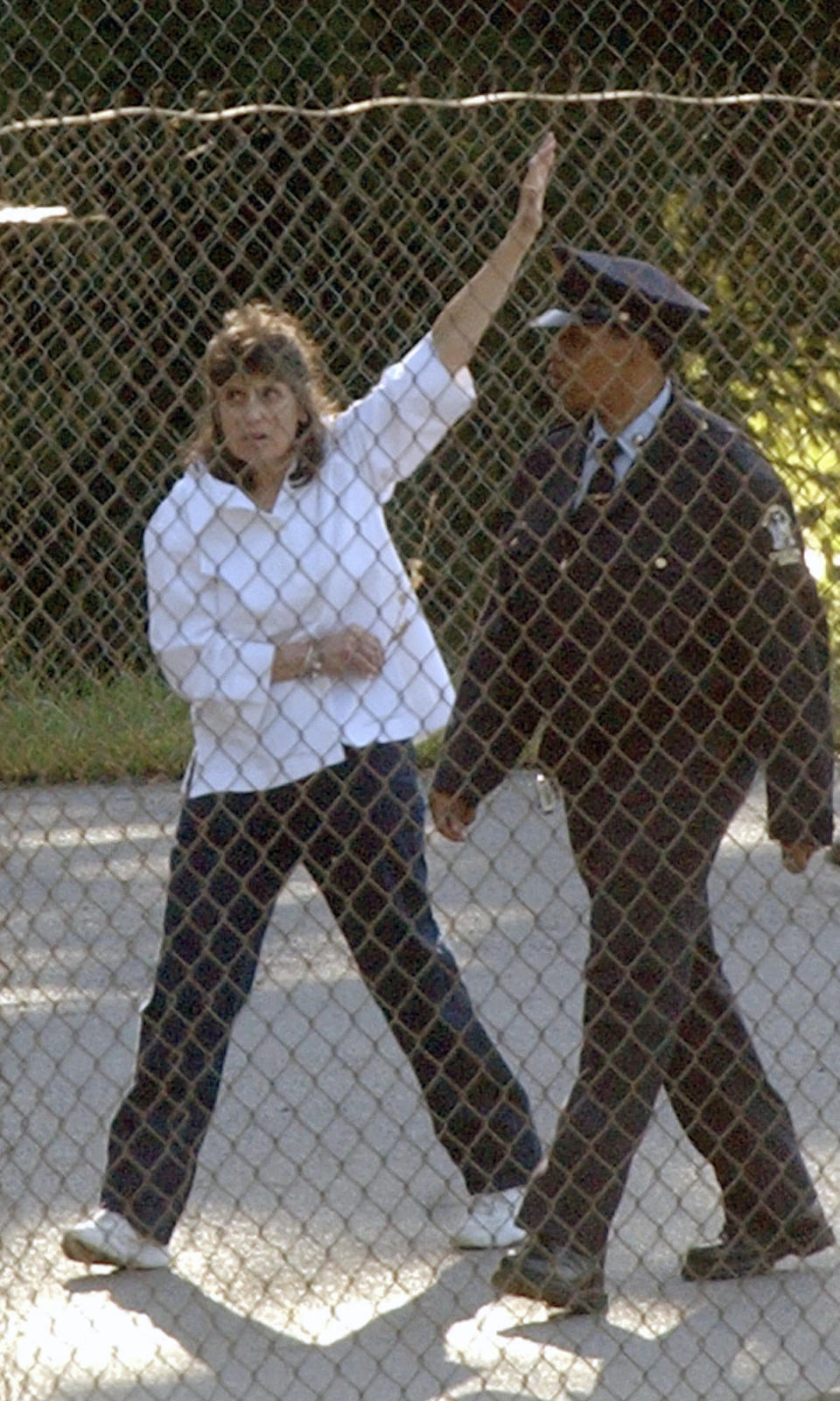 FILE - Kathy Boudin, left, waves as she leaves the Bedford Hills Correctional Facility escorted by a corrections officer, Sept. 17, 2003 in Bedford Hills, N.Y. Boudin, a former member of the radical Weather Underground who spent more than two decades in prison for her role in a fatal 1981 armored truck robbery and then spent decades helping other inmates, has died, Sunday, May 1, 2022, at age 78. (AP Photo/Mary Altaffer, File)