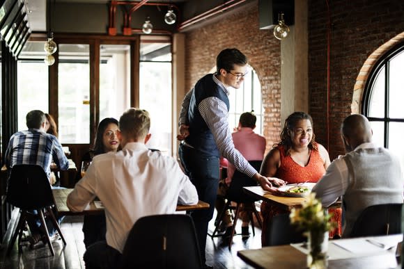 A waiter serves a dish at a casual restaurant.