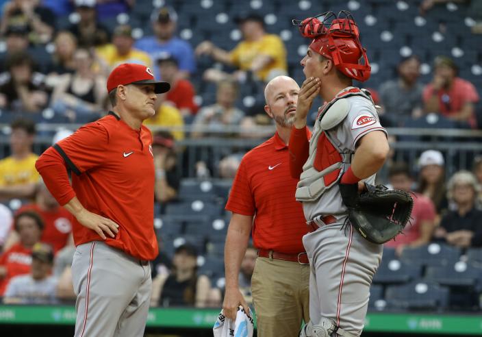 May 14, 2022; Pittsburgh, Pennsylvania, USA; Cincinnati Reds manager David Bell (left) and a Reds trainer check on catcher Tyler Stephenson (37) after Stephenson was hit in the jaw by a foul ball against the Pittsburgh Pirates during the third inning at PNC Park. Stephenson would leave the game. Mandatory Credit: Charles LeClaire-USA TODAY Sports
