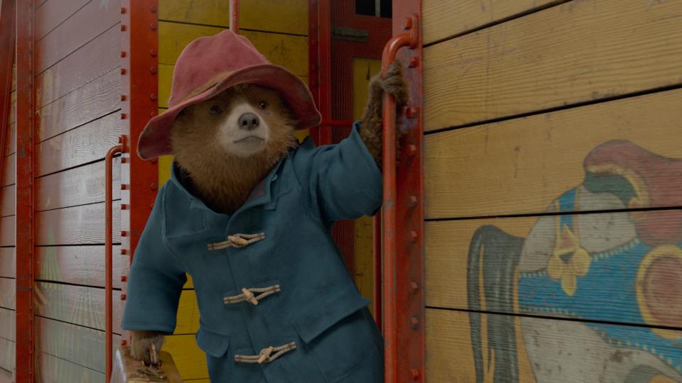 Paddington Bear leans out of the train in Paddington 2.