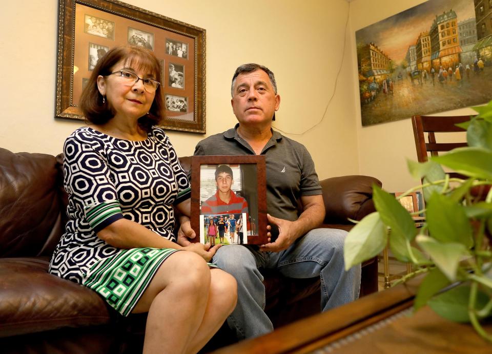 Boris Ochsenius Sr. and Teresa Contreras hold a photograph in 2020 of their son, Sebastian Ochsenius, who was murdered in their family home in 2014.