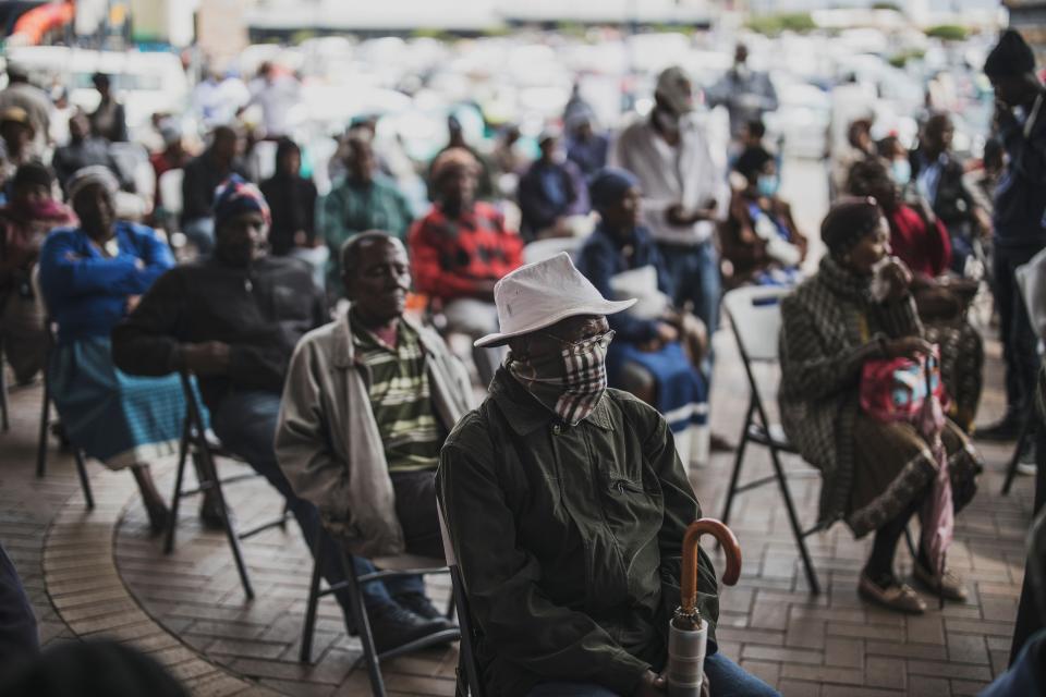 Image: An elderly man at a SASSA (South African Social Security Agency) pay-point in Soweto covers his mouth on March 30, 2020 while queuing. (Marco Longari / AFP - Getty Images)