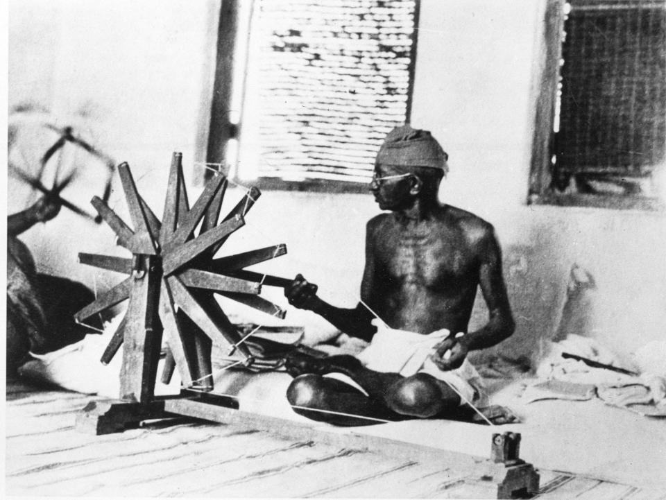 Mohandas "Mahatma" Gandhi sits and spins cotton in Ahmadabad, India, in this file photo taken circa 1931. Gandhi's wooden spinning wheel still stands among the simple throw pillows where he once sat cross-legged, threading cotton, receiving world leaders and promoting his vision of a unified, secular India. Today, just beyond the white-washed cottages of the independence leader's ashram, Muslims and Hindus have turned on one another with a ferocity not seen in a decade.