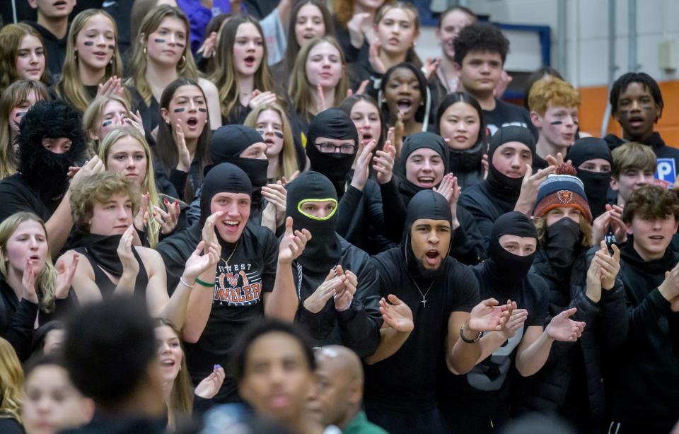 Masked Richwoods fans in the student section cheer for the Knights during player introductions before the start of their Class 3A boys basketball sectional title game against Metamora on Friday, March 1, 2024 at Pontiac High School. The Knights upset the defending champion Redbirds 61-55.