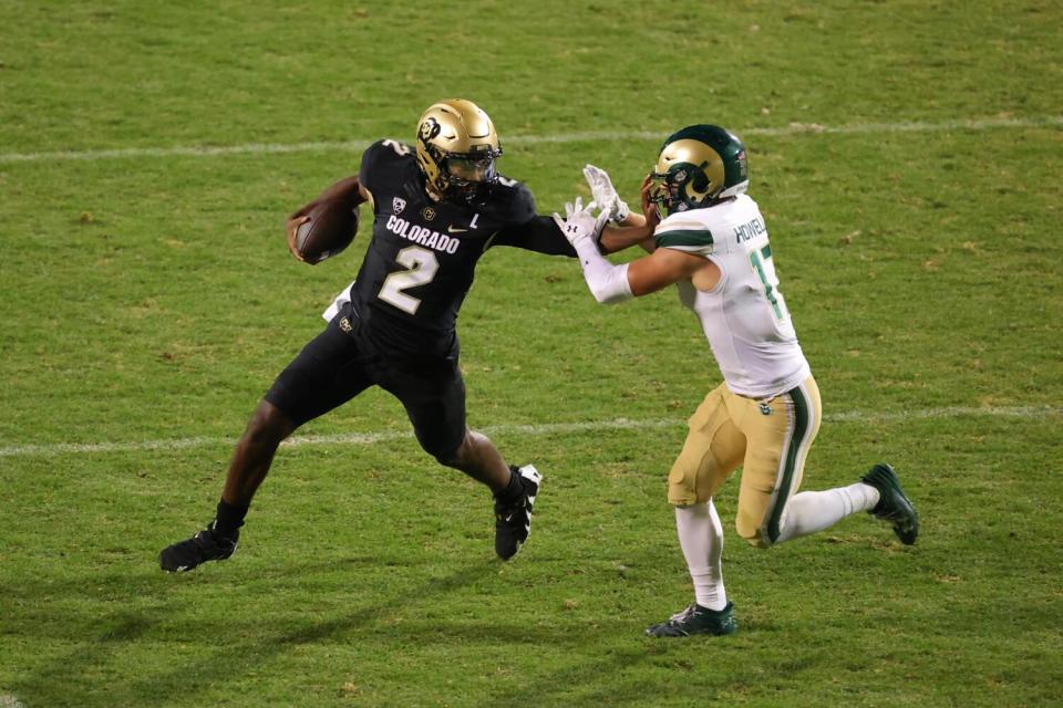 Colorado quarterback Shedeur Sanders stiff arms Colorado State defensive back Jack Howell