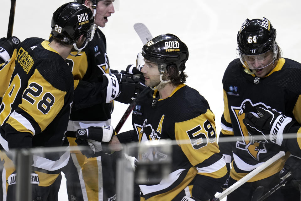 Pittsburgh Penguins' Kris Letang (58) is congratulated after scoring against the Montreal Canadiens during the second period of an NHL hockey game in Pittsburgh, Tuesday, March 14, 2023. (AP Photo/Gene J. Puskar)