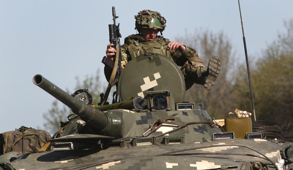 Ukrainian government troop sits atop of their armored personal carriers as they guard a checkpoint near the village of Dolina, 30 kilometers (18 miles) from Slovyansk, eastern Ukraine, Saturday, April 26, 2014. Ukrainian authorities are undertaking a security operation to liberate the nearby city of Slovyansk, which is currently controlled by an armed pro-Russian insurgency. (AP Photo/Sergei Grits)