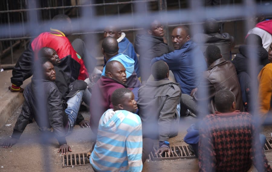 Zimbabwe opposition supporters sit inside a holding cell before their court appearance at the magistrates courts in Harare, Thursday, Aug, 17 2023. (AP Photo/Tsvangirayi Mukwazhi)