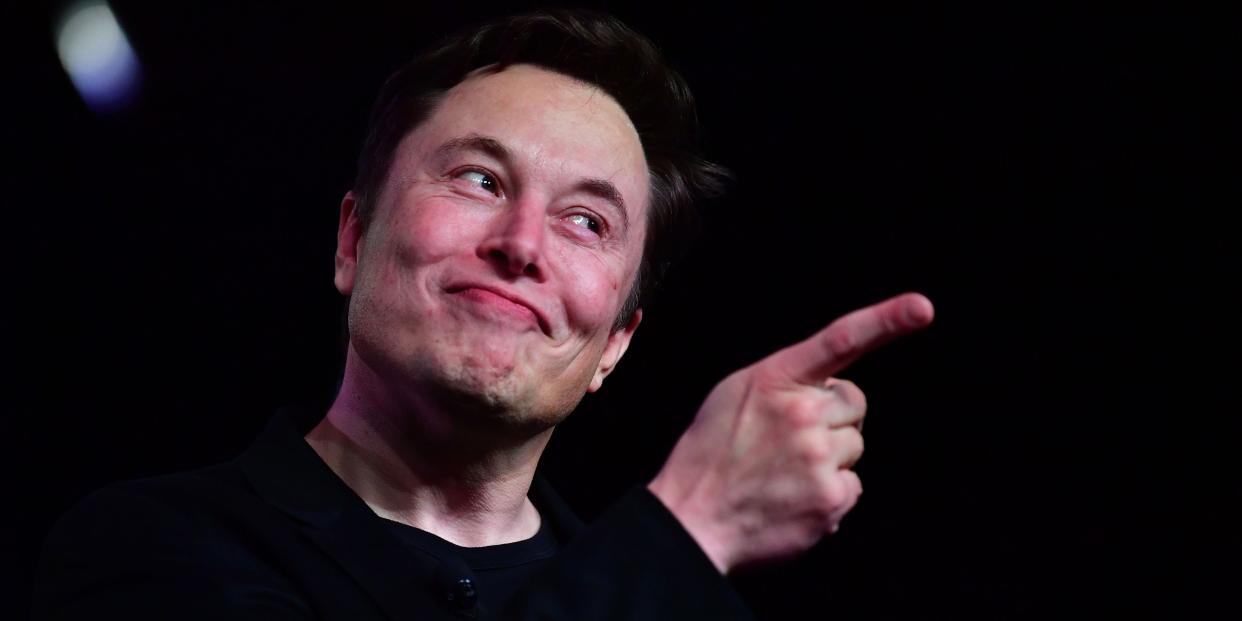 Elon Musk making a grimace and pointing a finger.