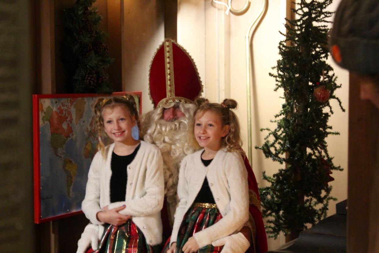 Children pose with Sinterklaas during his annual appearance on Friday, Dec. 3, 2021, at the Kerstmarkt in downtown Holland, Mich.