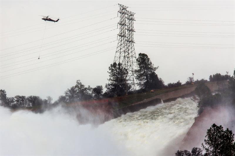 <p>Un helicóptero sobrevuela la presa Oroville y el río Feather con sacos cargados de rocas para aliviar la emergencia ocasionada por la erosión del desagüe en la represa Oroville hoy, lunes 13 de febrero de 2017, en Oroville, California (EE.UU.). Los trabajos de emergencia para reparar los daños en la presa Oroville, situada en el norte de California (EEUU), y las tormentas que en los próximos días podrían agravar la situación mantienen en vilo a las cerca de 200.000 personas que continúan evacuadas por un riesgo potencial de inundación. EFE/PETER DASILVA </p>